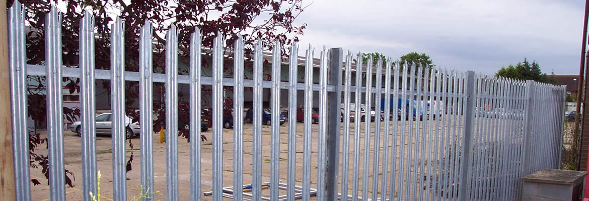 Galvanized palisade fencing is used to protect parking lots.